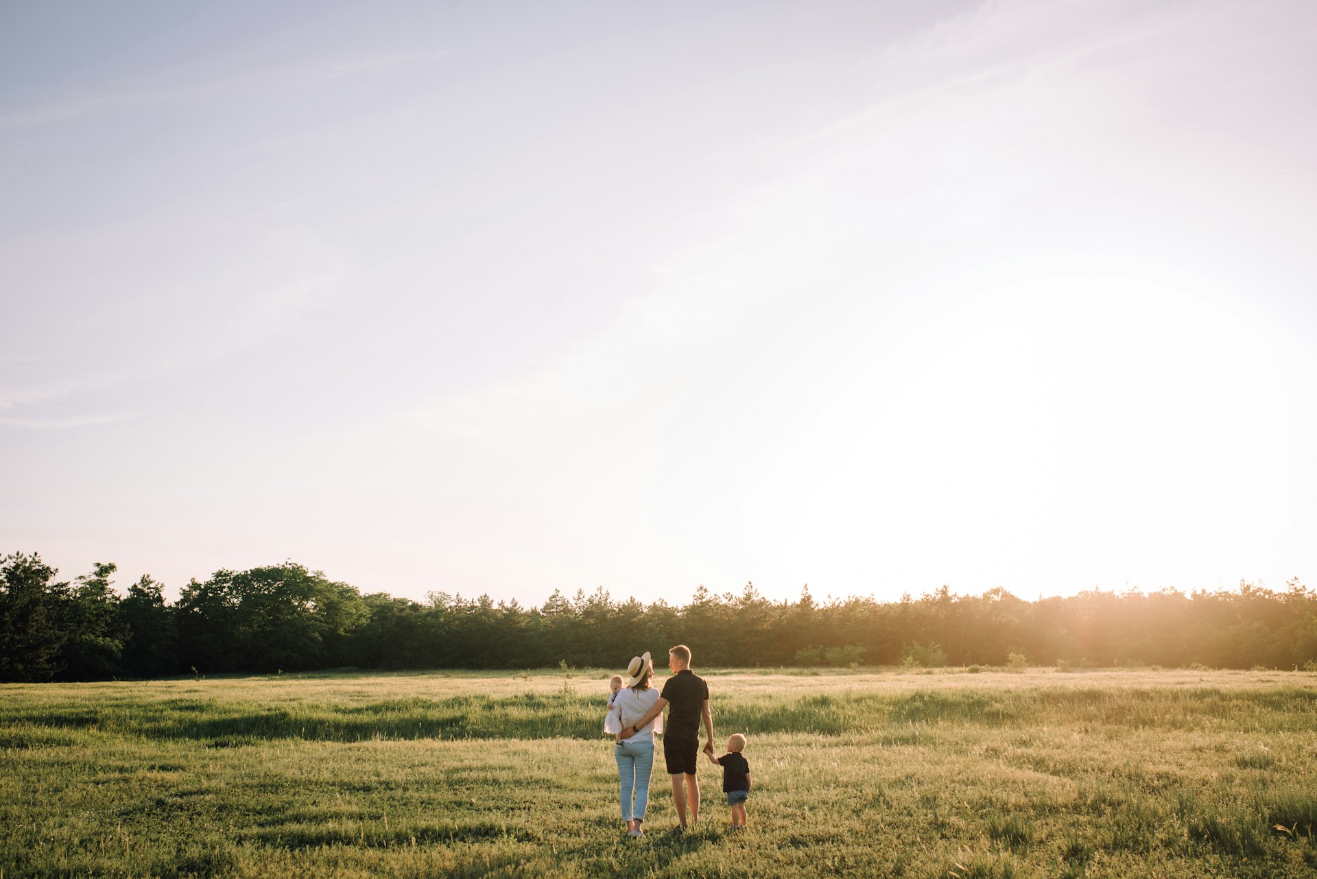 Family walking outside through a nice grass field