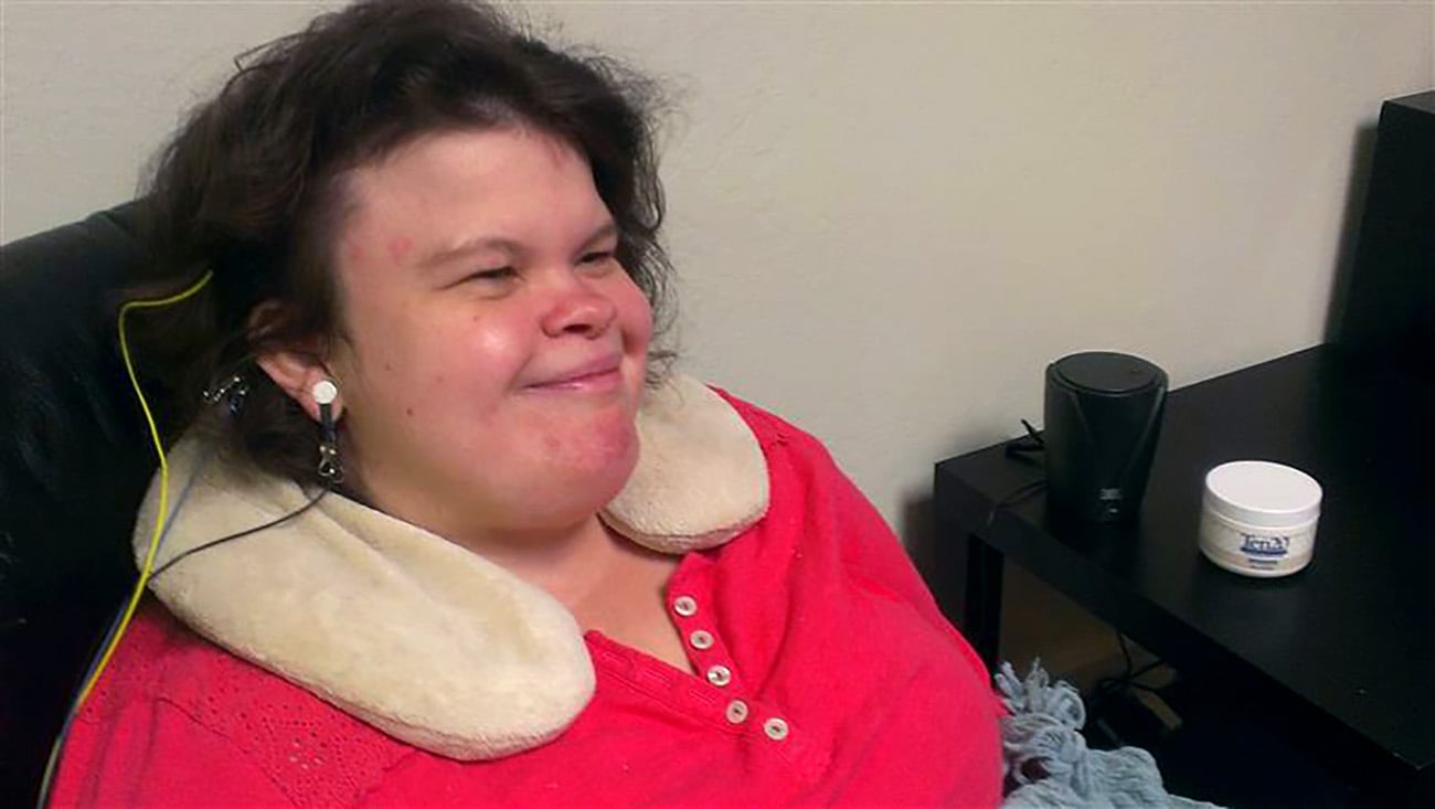 Young woman in a red top smiling while using neurofeedback headphones