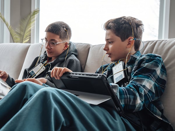High school student reading in front of a bookshelf during a NeurOptimal neurofeedback session