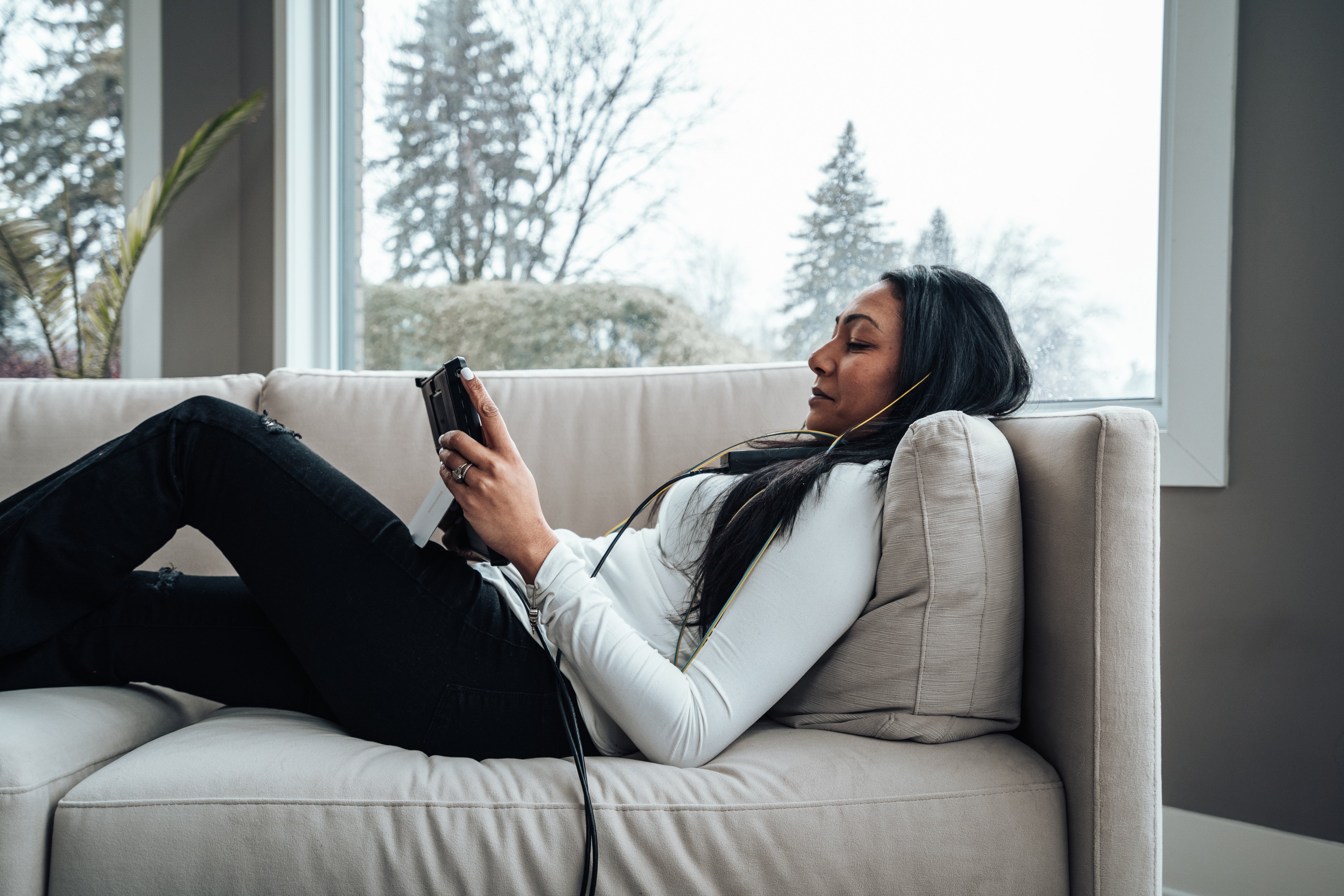 Women using neuroptimal system relaxing on couch