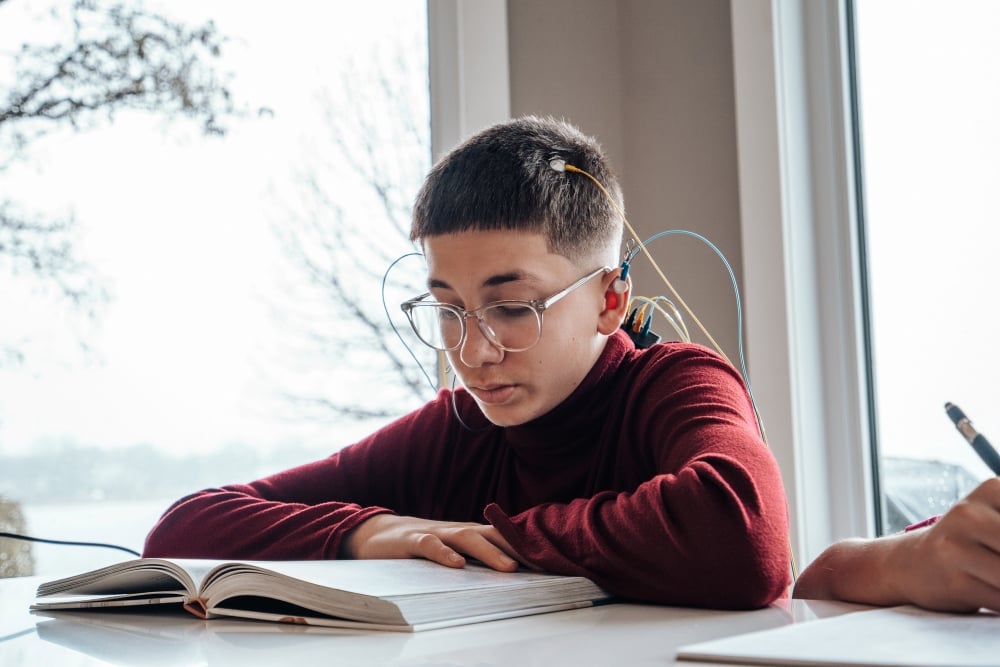 Male child using neuroptimal system doing homework