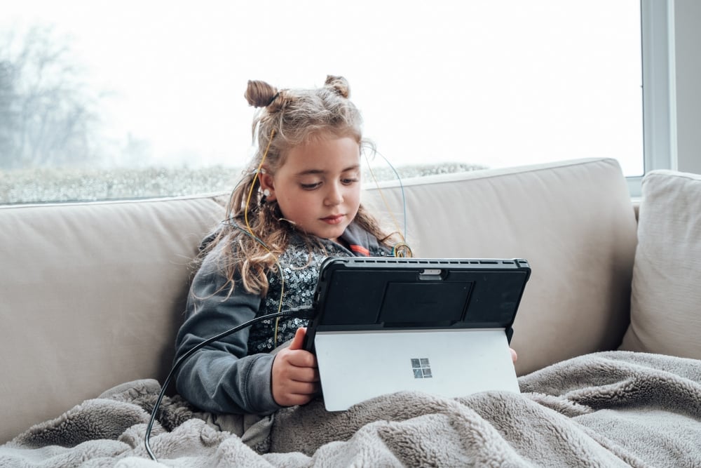 female child using neuroptimal system relaxing on couch